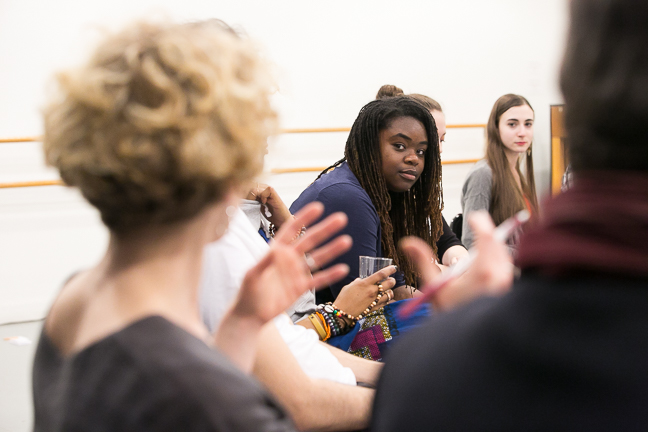 shared space Image description: Over someone's shoulder, a person is seated, looking intently towards the camera.